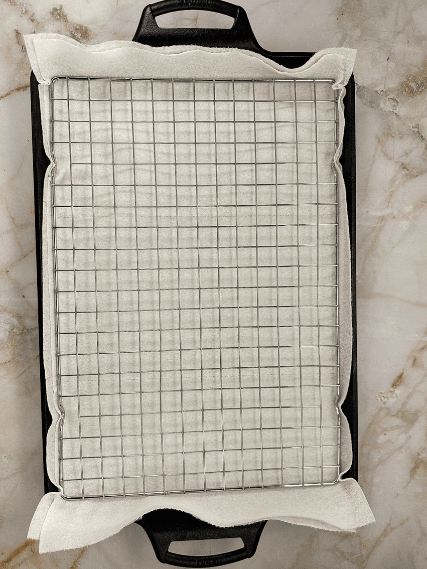 A wire rack over paper towels on a baking sheet.