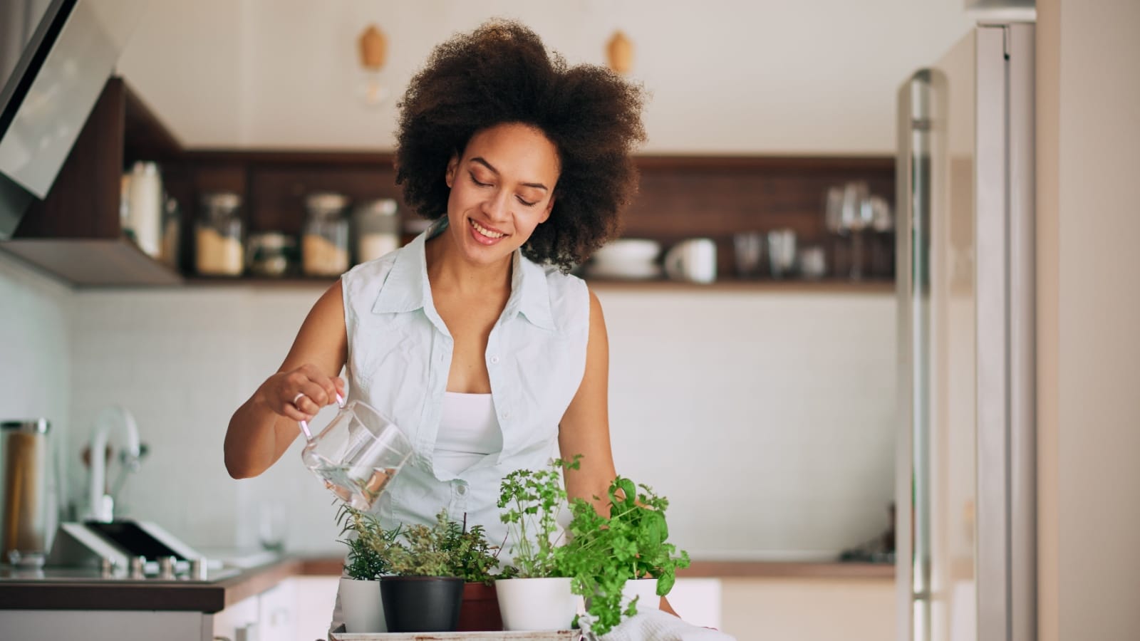 woman watering herbs.