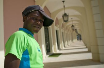 Teenager With A Cap In Front Of The National Bank Of Angola In Luanda, Angola