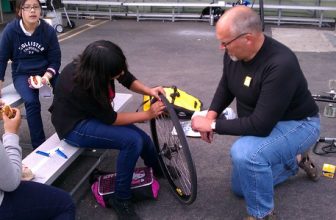 Joe Linton teaching a young woman how to patch a tube