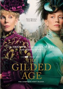 the gilded age season 1 poster with Christine Baranski in deep purple velvet and a BIG HAT standing back to back with a younger woman with brown hair and a teal shiny gown 