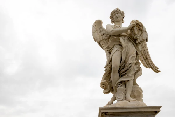 An angel holds the crown of thorns gazes heavenward, showcasing the delicate craftsmanship of Bernini's design against the Roman sky. Credit: Daniel Ibáñez/CNA