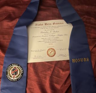 Ronisha Niki Baker displays her associate degree and honors sash