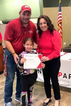 ASPSF volunteer, Shana Pierce, presents Poinsett County student Harden Daniels and daughter with his certificate and check at an Arkansas Single Parent Scholarship Fund awards ceremony on Feb. 3 held at St. Bernards Auditorium.