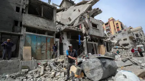 Reuters Palestinians inspect the aftermath of an Israeli strike on a house in Gaza City, northern Gaza (24 April 2025)