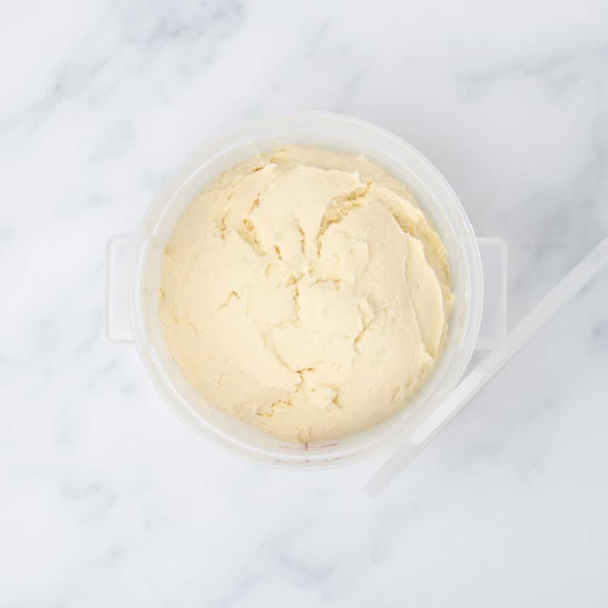 same raw dough in bucket after having risen