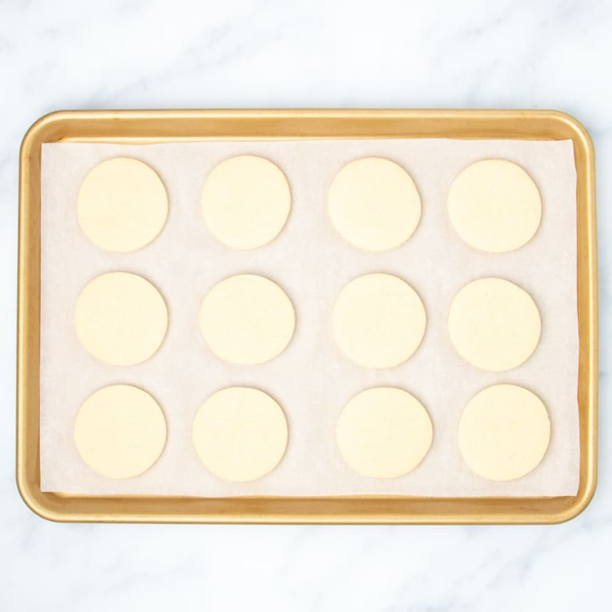 same baking sheet with 12 baked sugar cookie rounds
