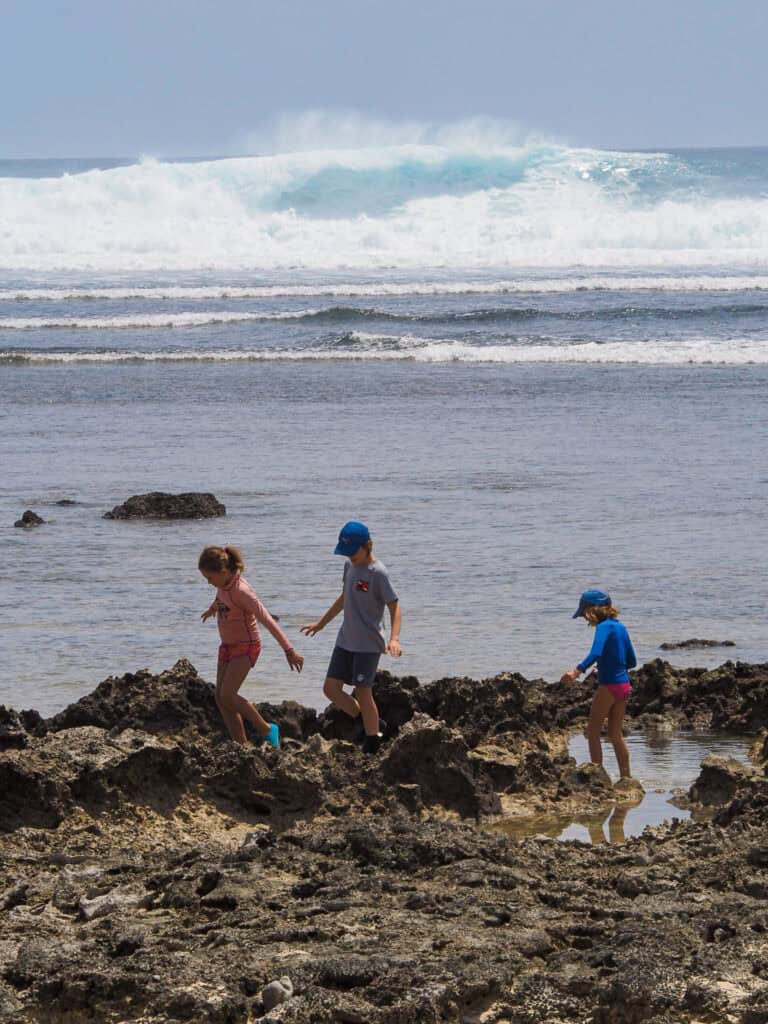 Children exploring rock pool on the beach in Siargao