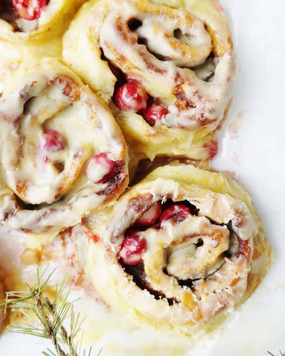 Close up of three cinnamon rolls topped with icing.