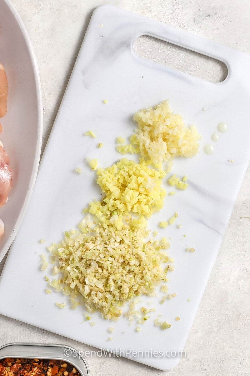 slicing ginger and garlic with lemongrass to make Lemongrass Chicken