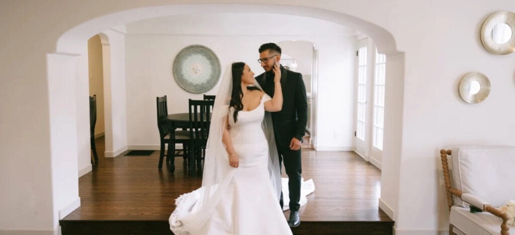 Bride and groom posing under arch inside home