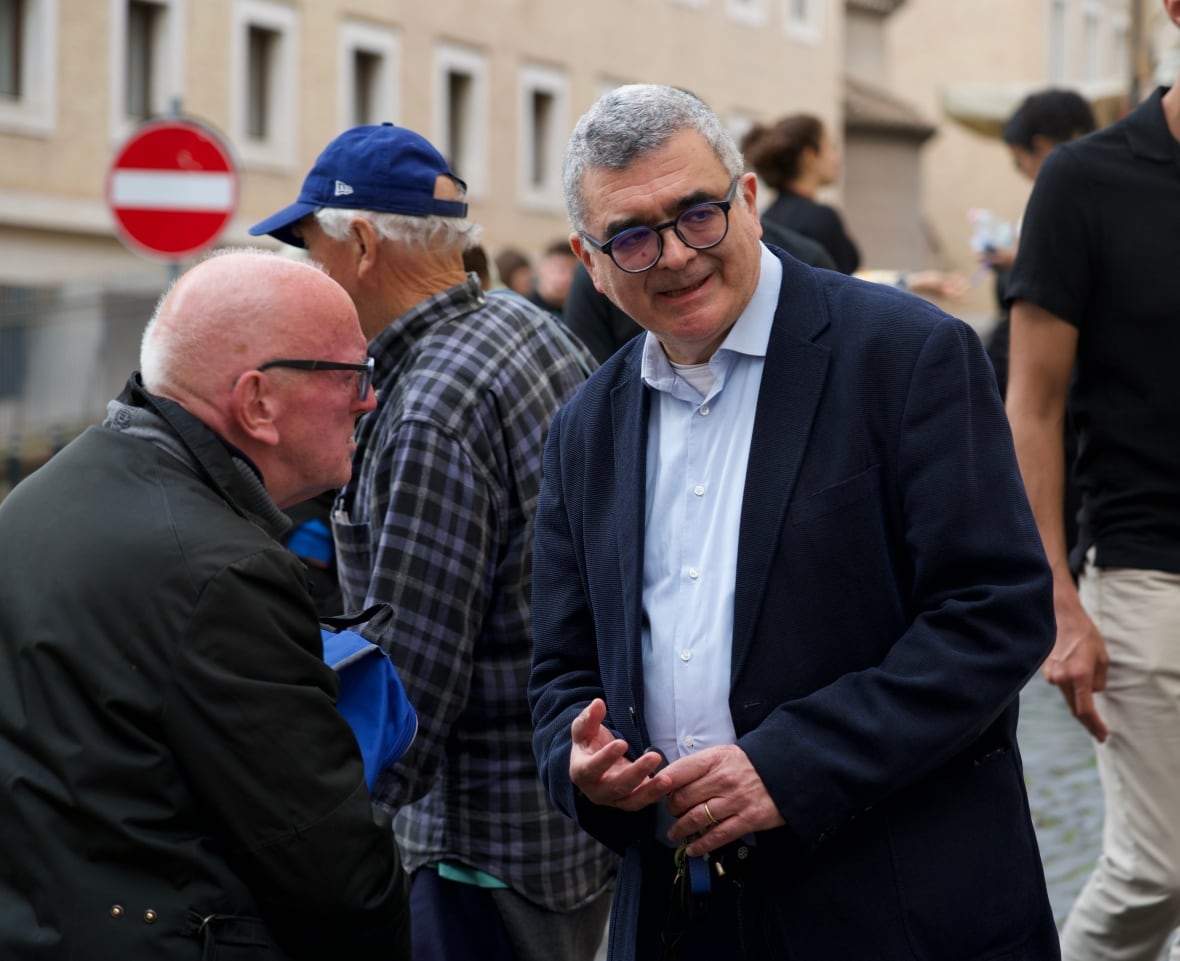 Carlo Santoro,  the director of Palazzo Migiliori, which is run by Sant'Egidio Community, welcomes residents as they arrive at the shelter on Wednesday. 