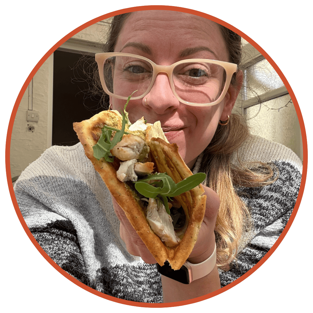 Author Sarah Howells holding a cottage cheese flatbread with a salad filling, looking very excited about it.