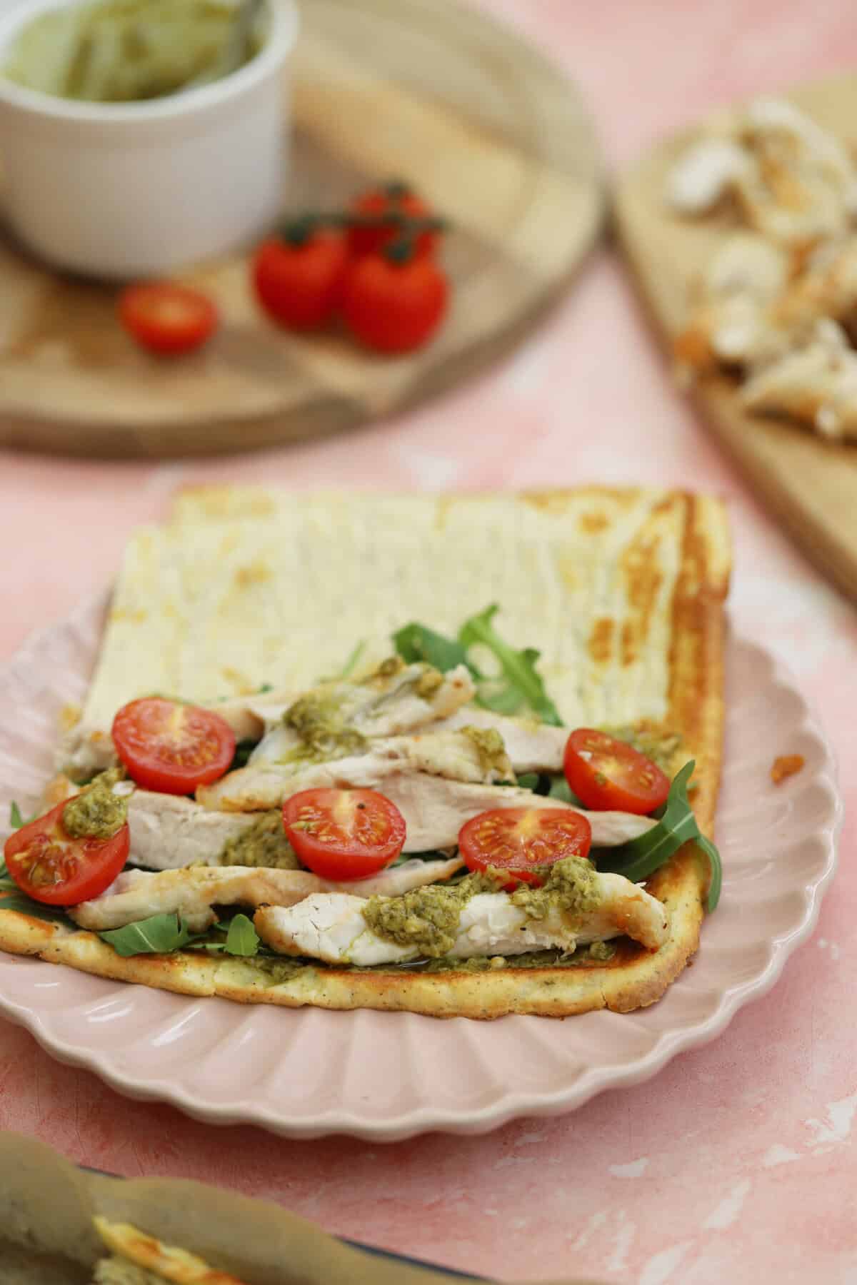 A cottage cheese flatbread over a filling of chicken, tomato and rocket.
