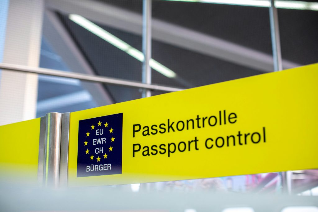 A passport control sign with the EU logo included