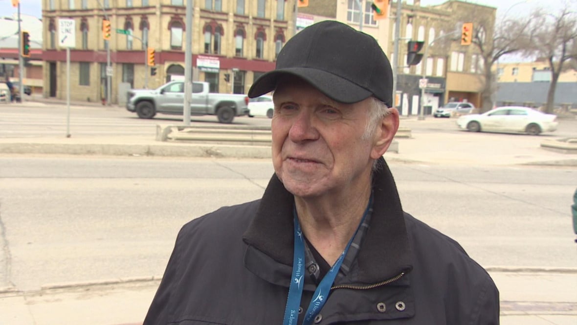 A man in a black jackets looks at the camera.