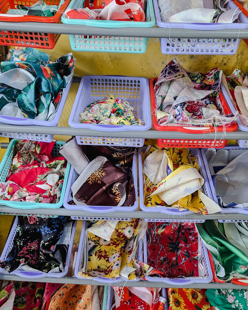 Silk fabric scraps in boxes on the wall at a Hoi An craft workshop