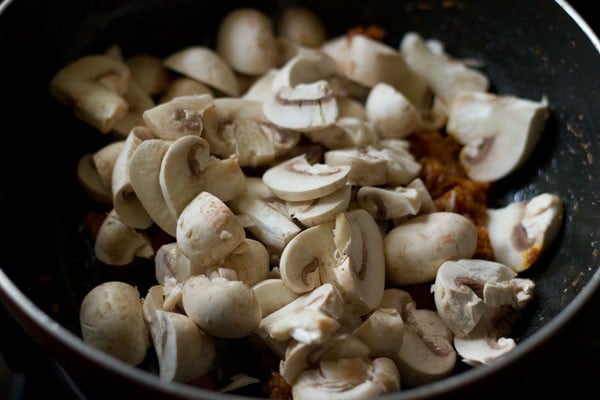 chopped mushrooms added to onion-tomato masala in the pan.