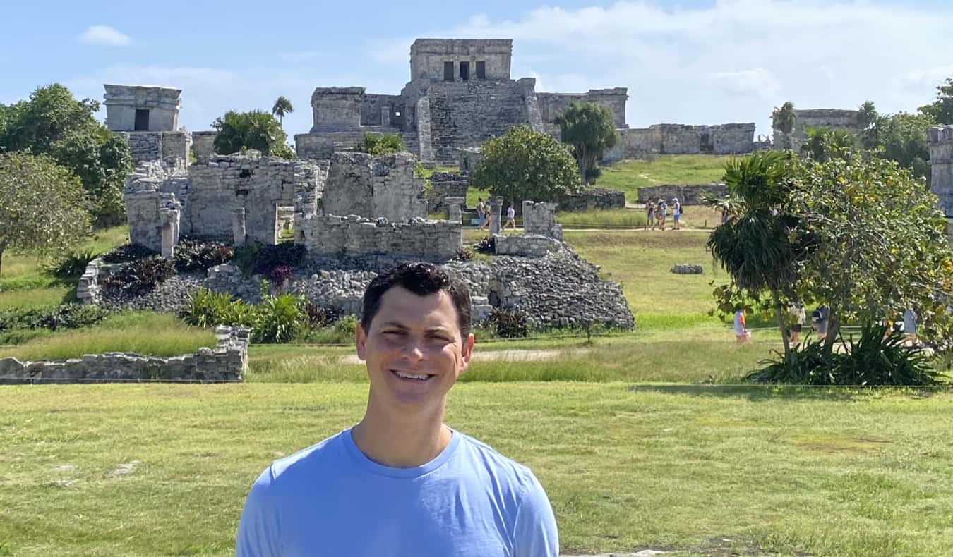 Nomadic Matt posing near the ruins in Tulum, Mexico on a sunny day