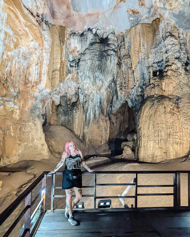 Milly is stood in Phong Nha cave, a tall cave with dangling rock formations above her