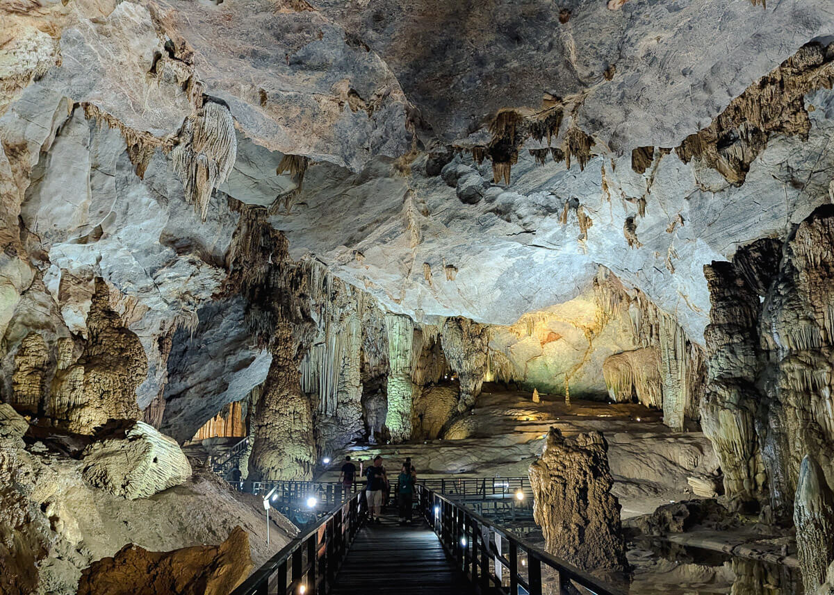 Paradise Cave: A large cave with illuminated rock formations surrounding a wooden boardwalk