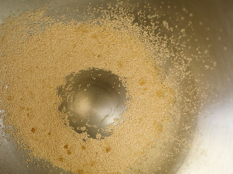 instant yeast and sugar added in a stand mixer bowl for pita bread recipe. 