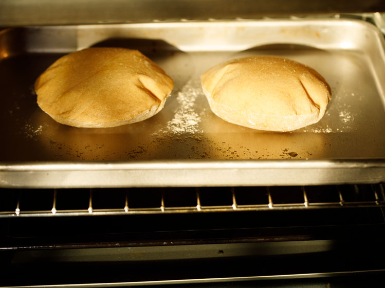 pita breads baking and puffing in the oven. 