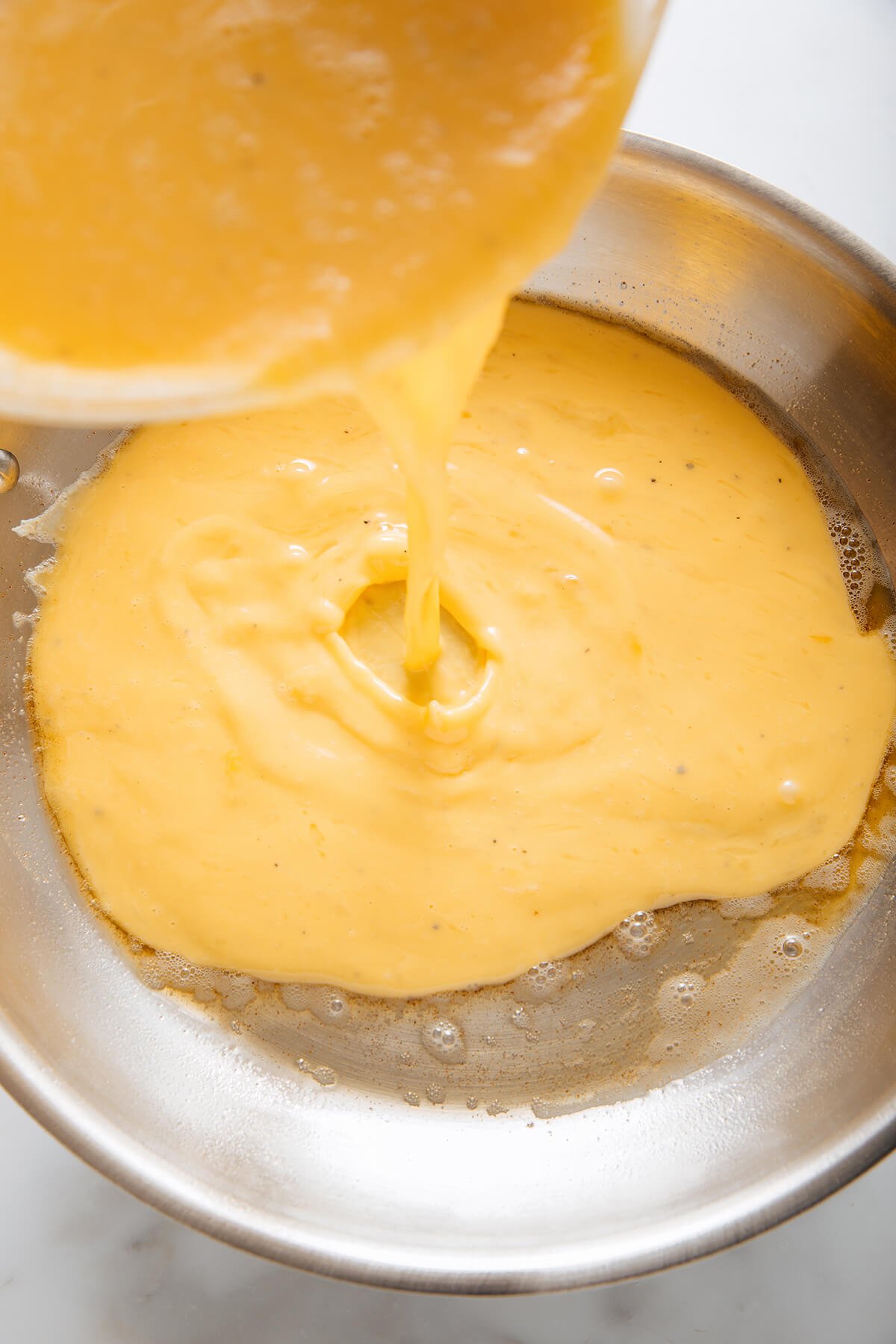 pouring eggs into skillet