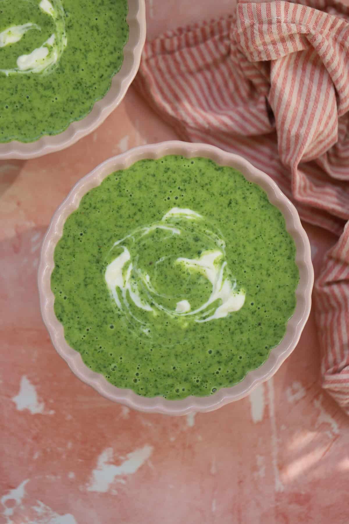 A bowl of watercress soup swirled with creme fraiche.