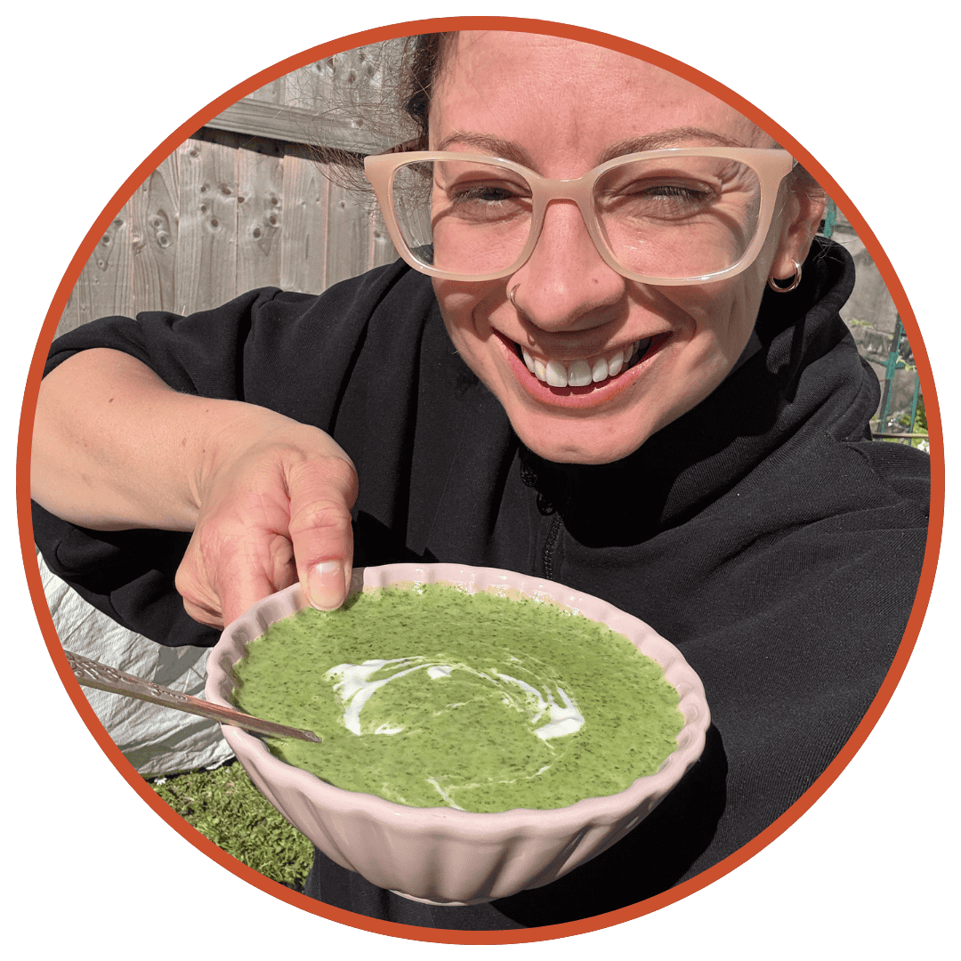 Author Sarah Howells looking very happy in the garden holding up a bowl of watercress soup.