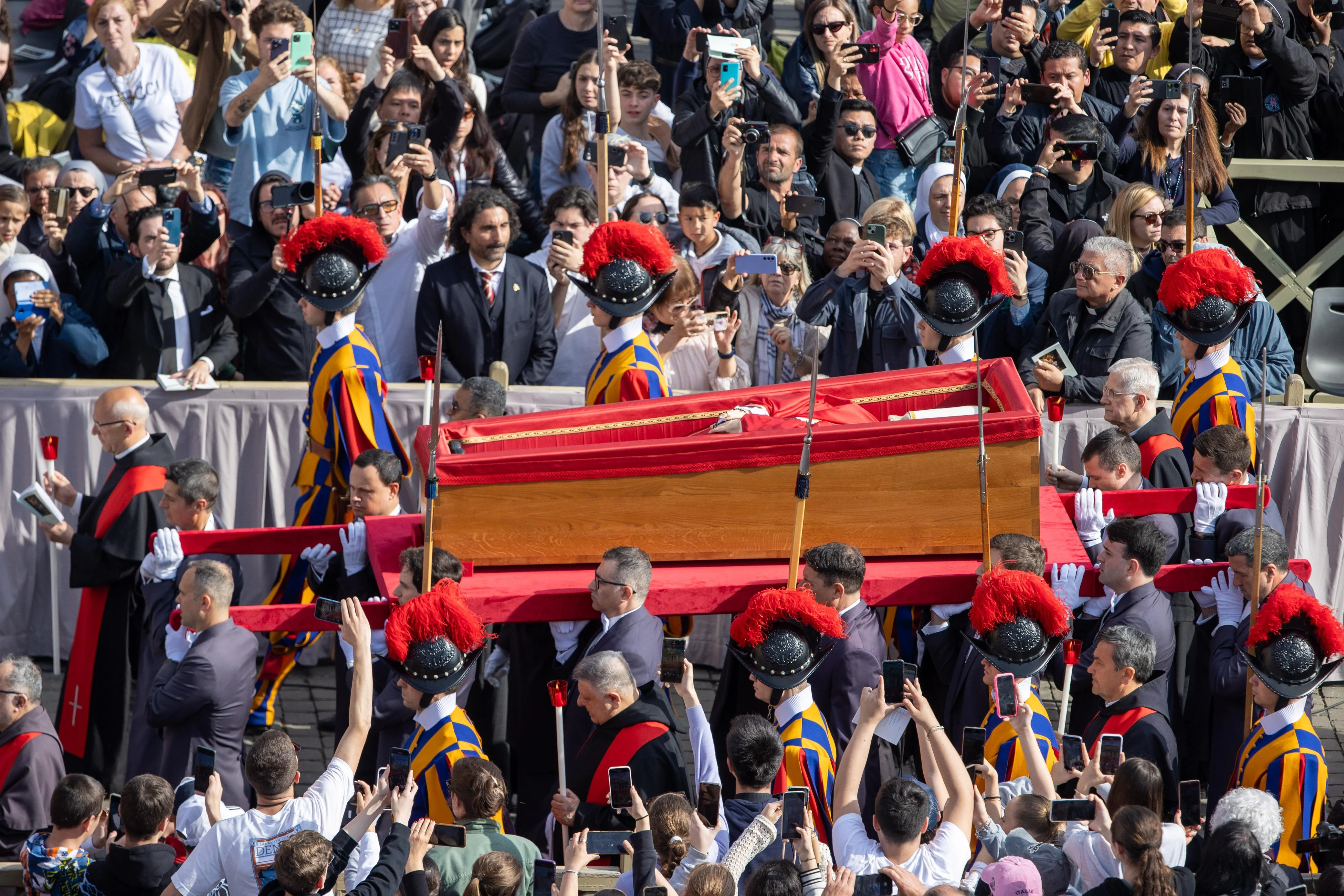 Swiss Guards accompany the pallbearers with the wooden coffin of Pope Francis in St. Peter’s Square on April 23, 2025, during the translatio — the solemn transfer of the pope’s body for public viewing ahead of Saturday’s funeral Mass. | Credit: Daniel Ibáñez/CNA