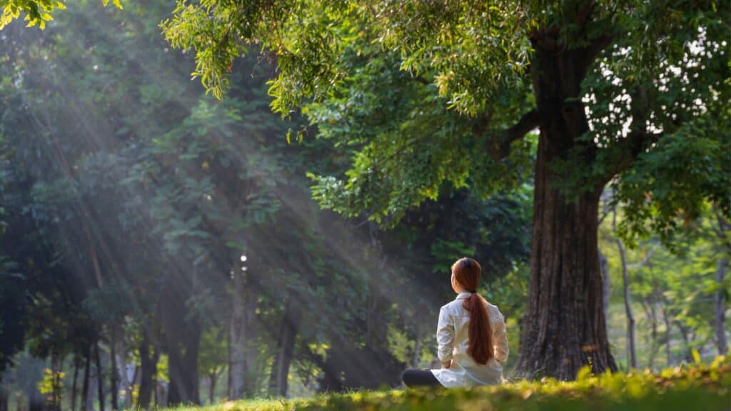 woman meditating in field.
