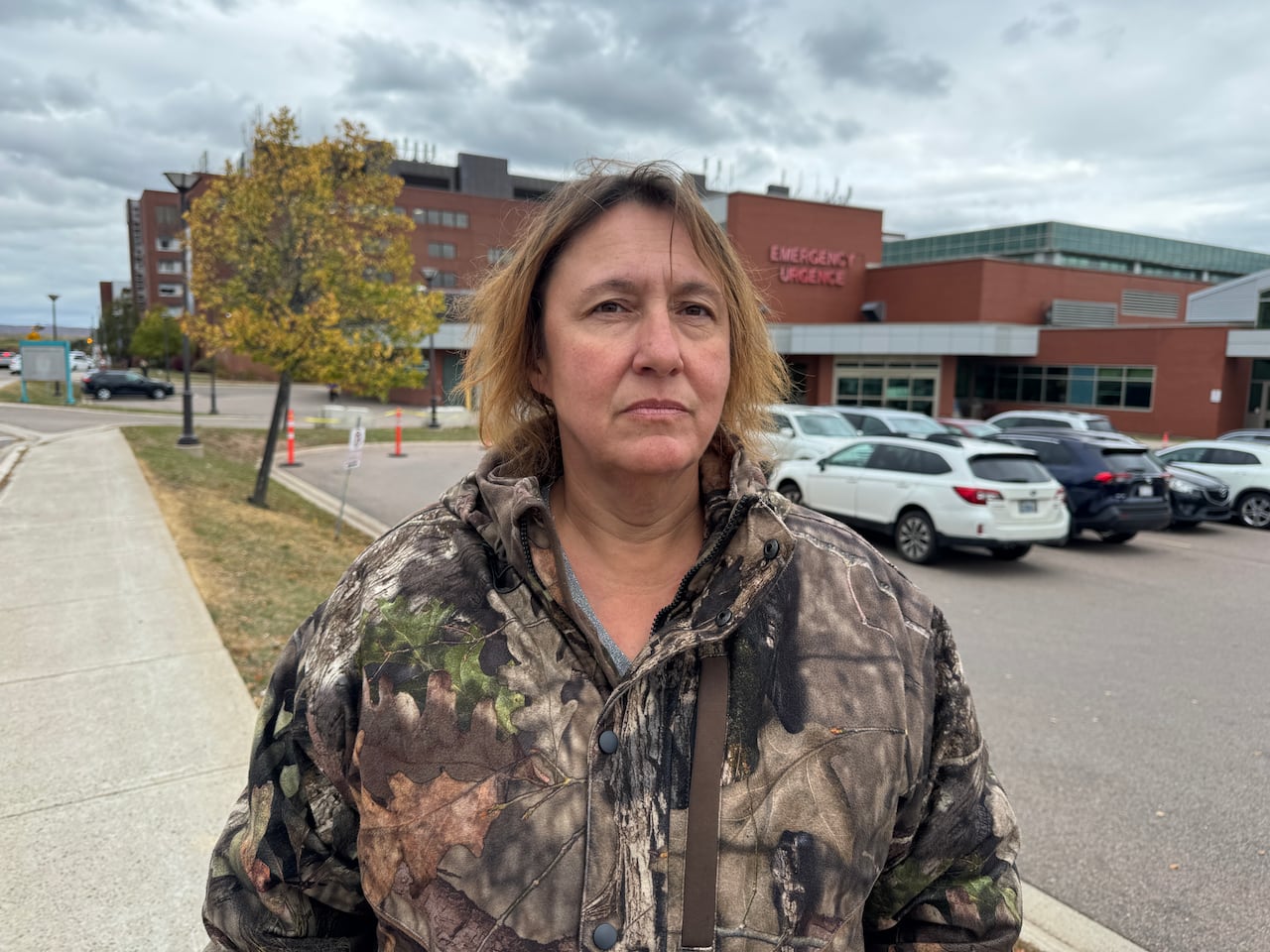 A woman standing in front of a hospital
