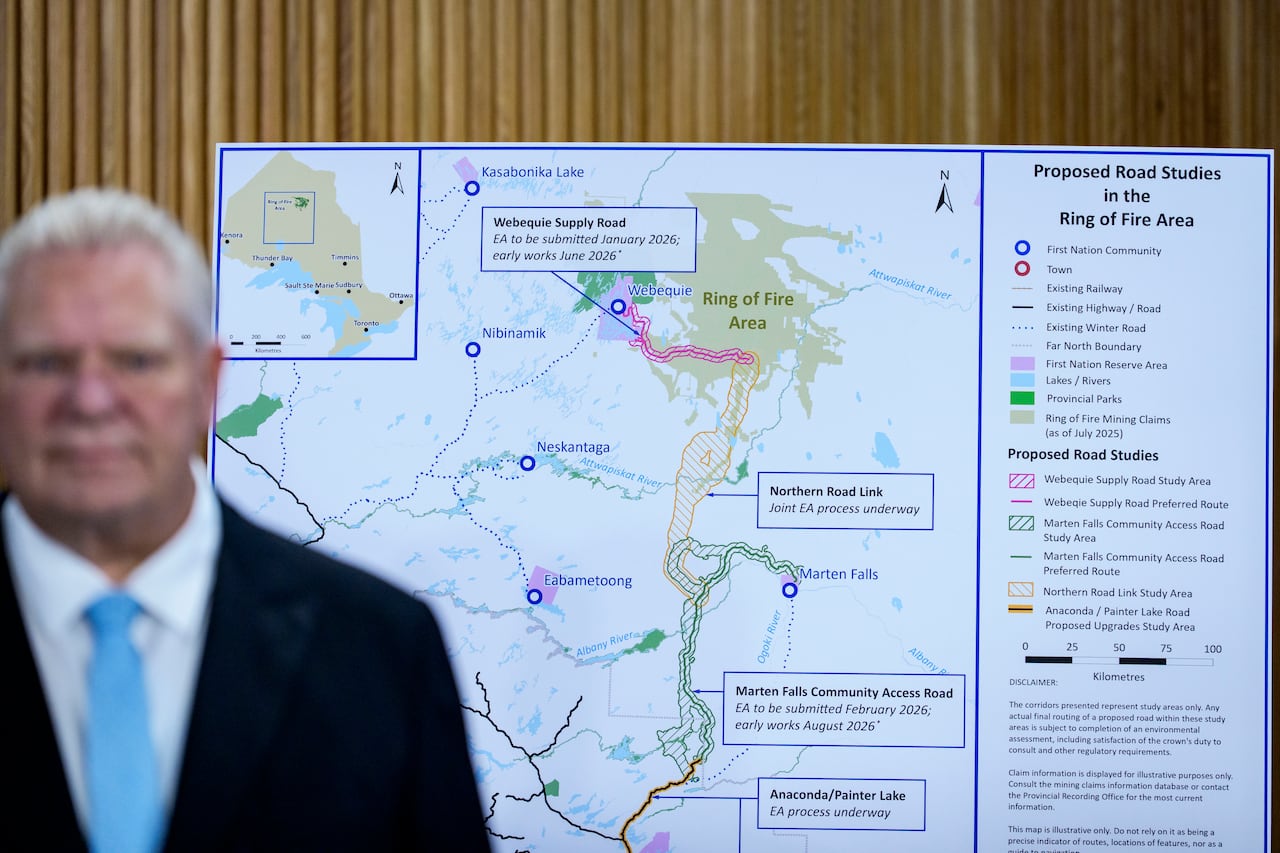 A person is seen standing in front of a large map.