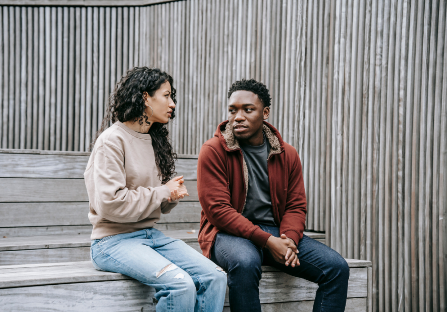 young couple sitting on bench talking silent red flags in a relationship 