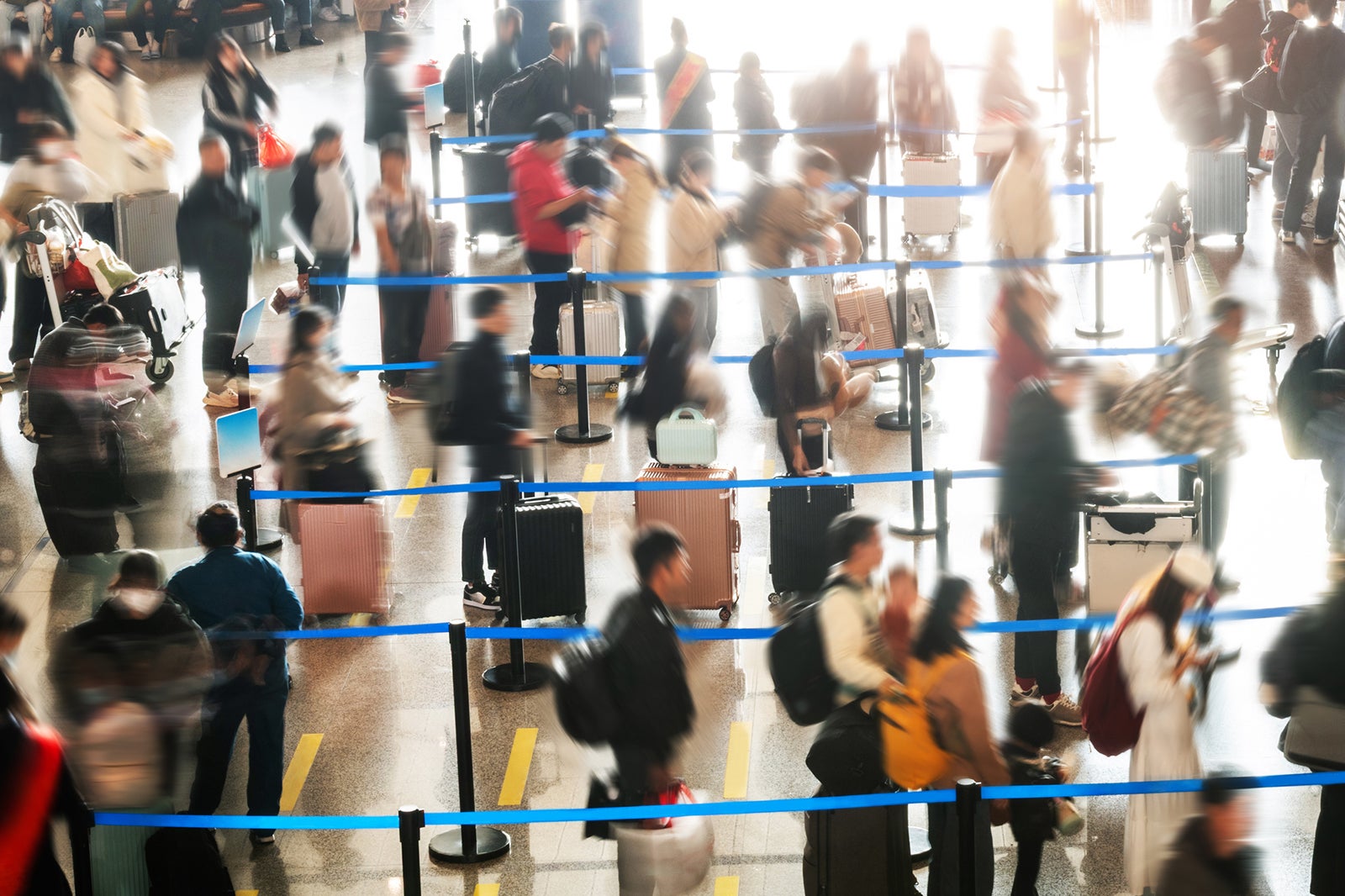 Crowded commuter people with luggage in airport waiting for check-in