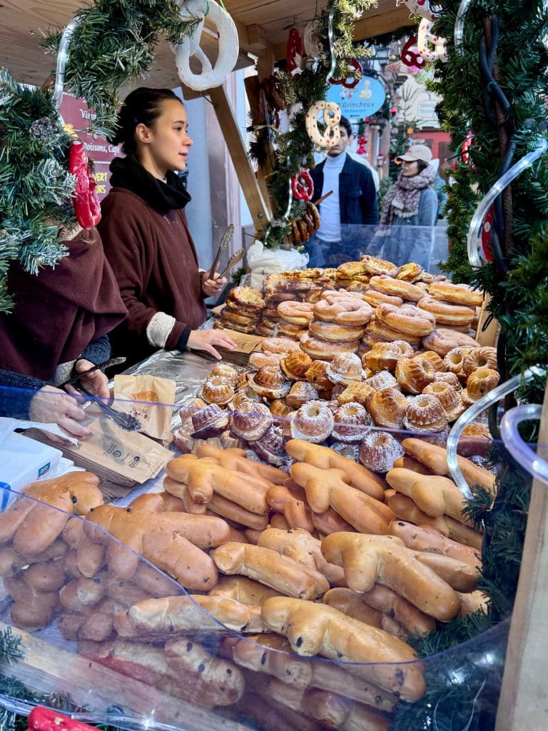 An outdoor vendor selling piles of Alsatian breads and pastries.