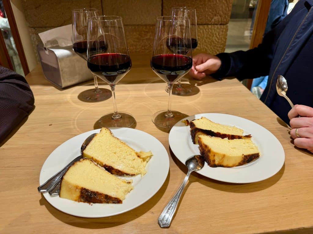 Two plates each topped with two slices of a burnt cheesecake.
