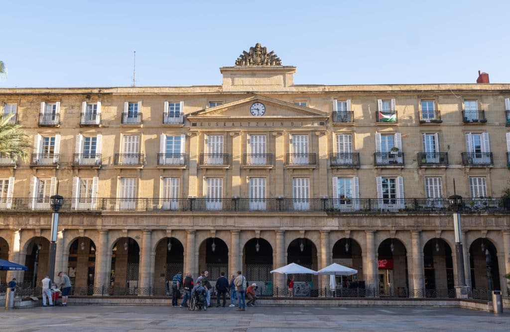 A stately stone building with porticoes on a plaza.