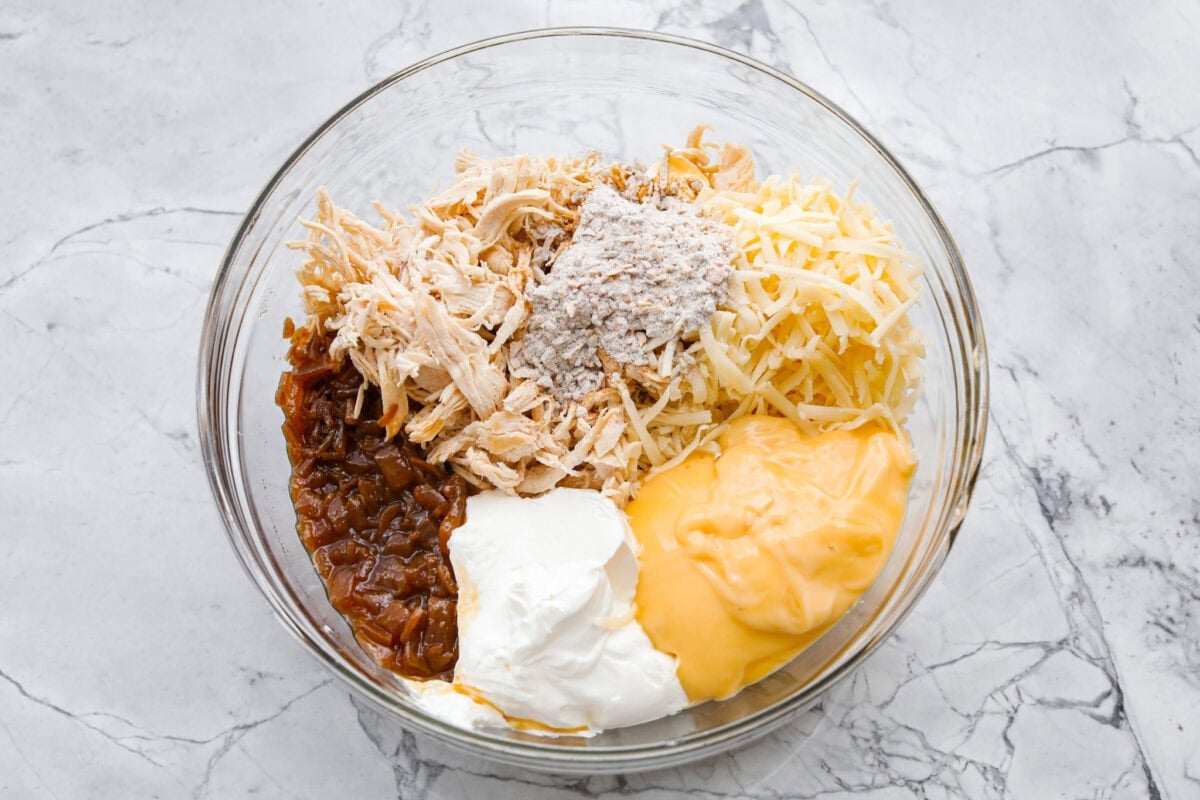 Creamy, cheesy, and packed with shredded chicken, this French onion chicken casserole is comfort food at its best! Inspired by French onion soup and dip, it’s topped with crispy fried onions for a crunchy finish. Casserole ingredients all added to a mixing bowl.