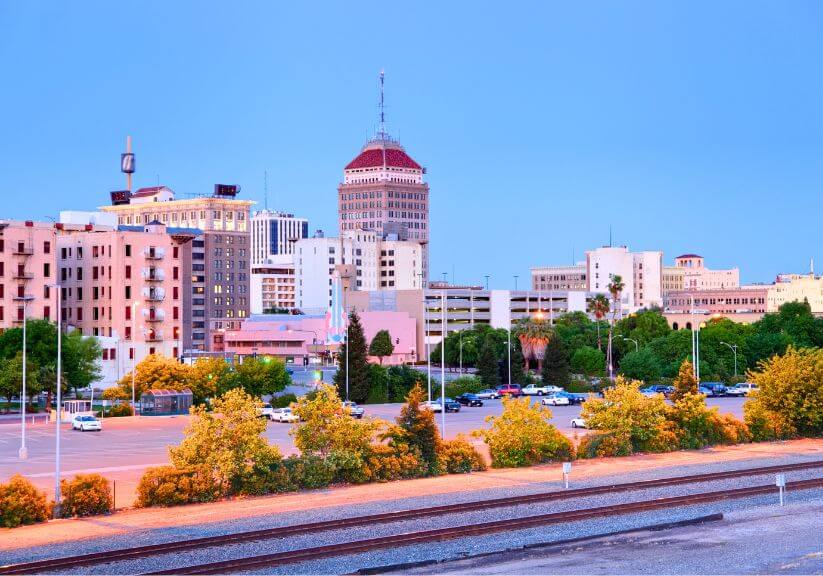 City skyline at dusk with greenery.