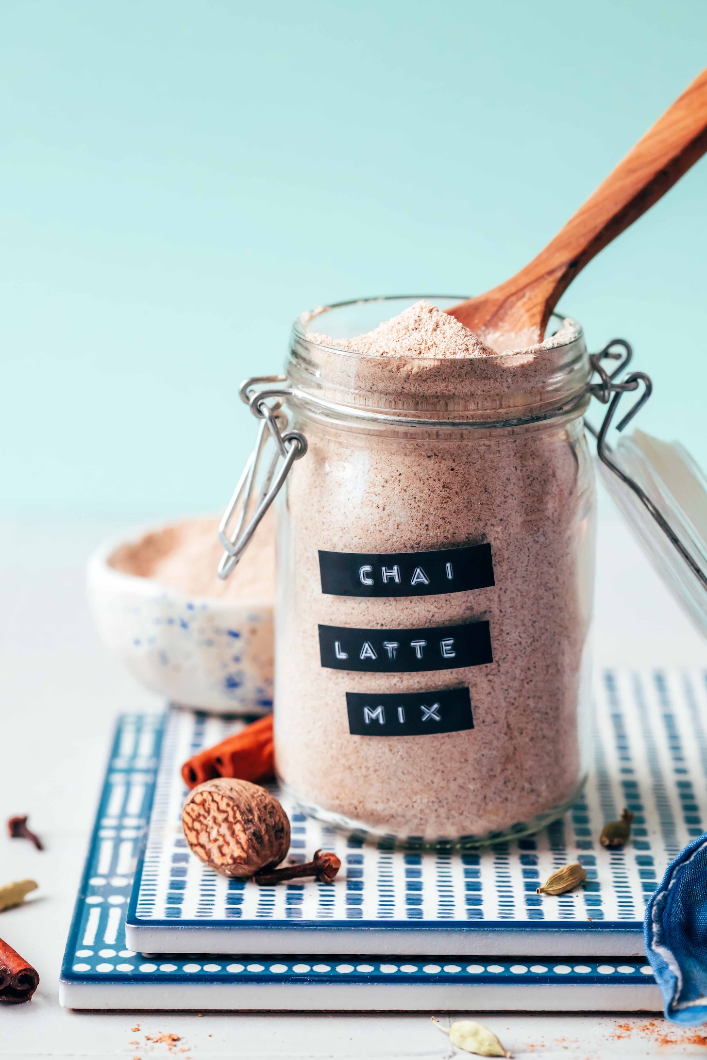 Wooden spoon resting in a glass jar of Instant Chai Latte Mix