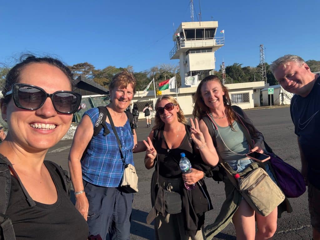 Kate and friends taking a selfie at Nosy Be airport, with peace signs.