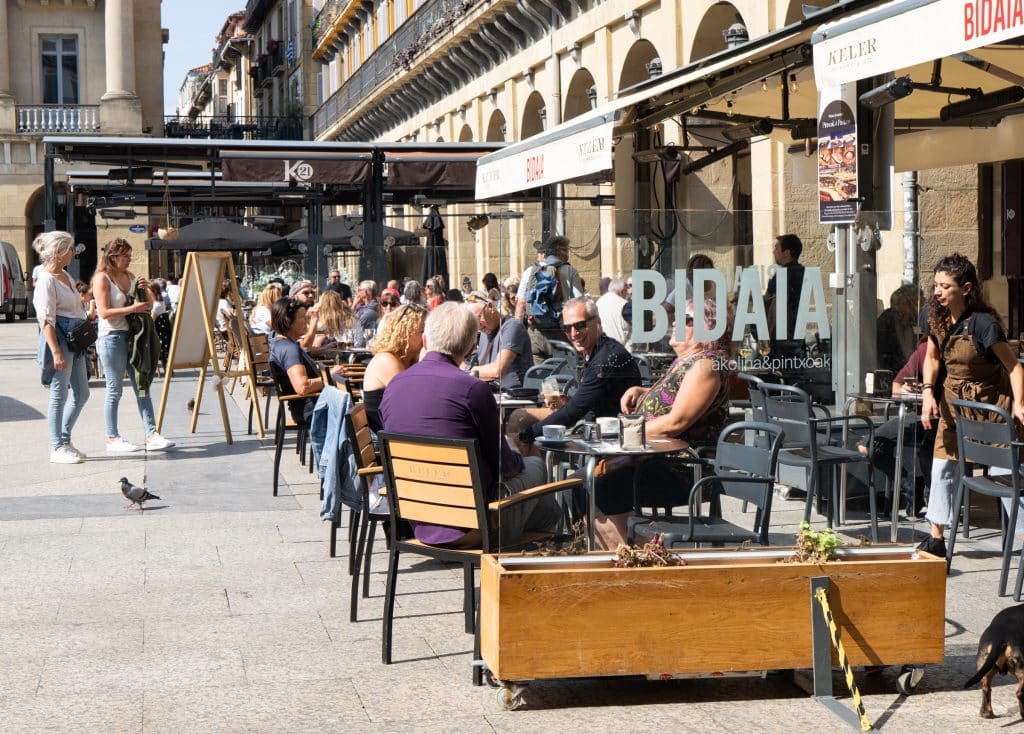 People sitting and enjoying tapas at an outdoor restaurant.