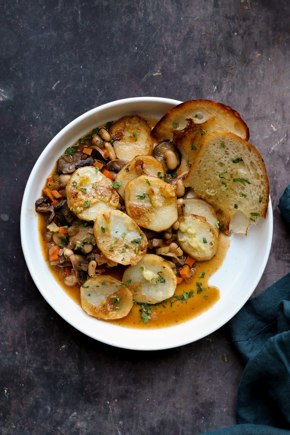 mushroom potato casserole in a bowl with garlic bread