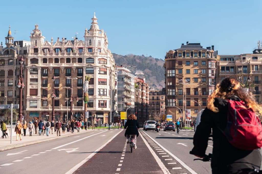 Two women riding bikes down a bike lane in San Sebastián.