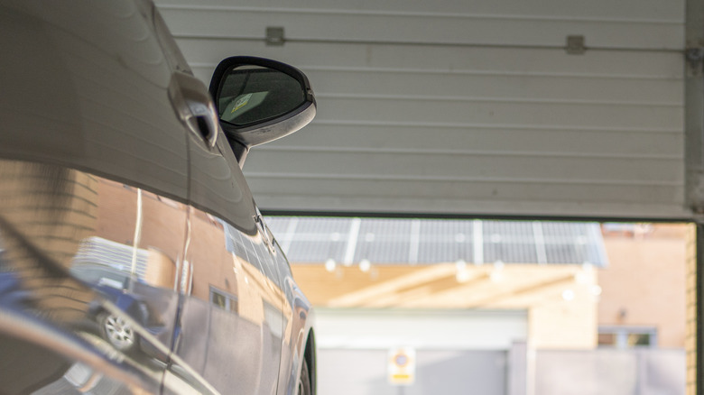 A low-angle view of a garage with a parked car inside.