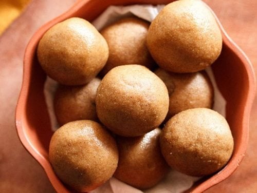 atta ladoo served in a brown bowl.