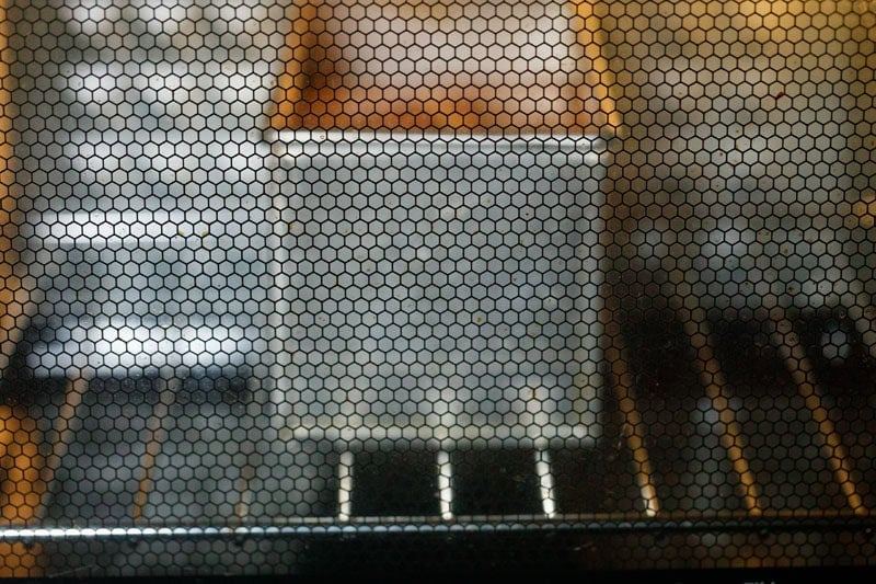 Metal baking pan in oven with lemon cake being baked.