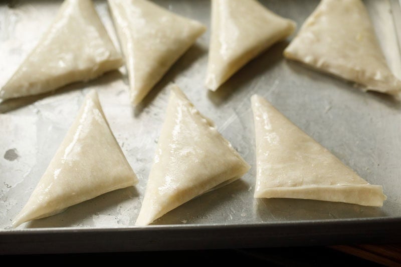 Unbaked irani samosa arranged on tray.
